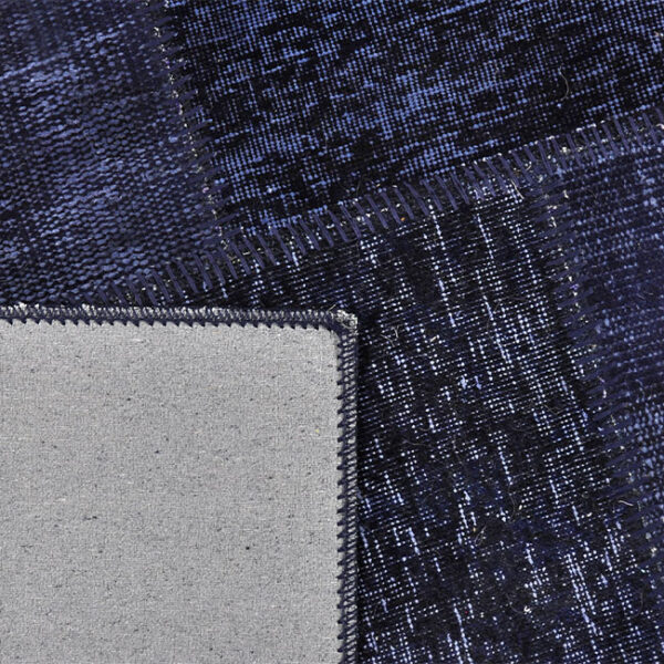 Achterkant hoek aanzicht van vloerkleed ANKARA patchwork, in de kleur donker blauw gemaakt van wol.