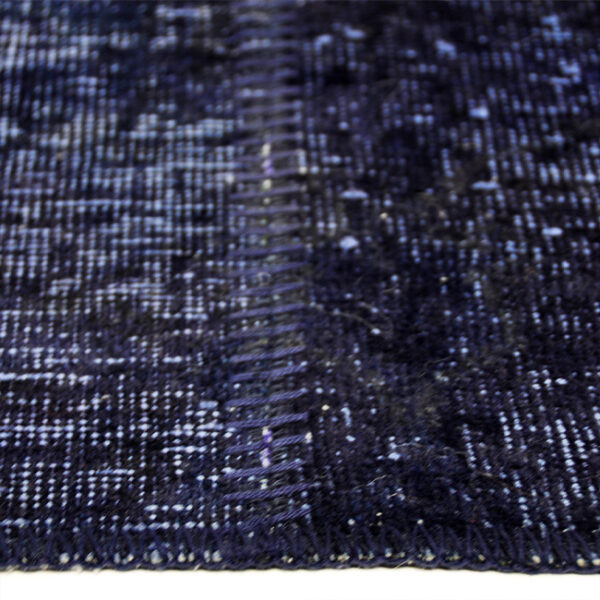 Zijkant detail aanzicht van vloerkleed ANKARA patchwork, in de kleur donker blauw gemaakt van wol.