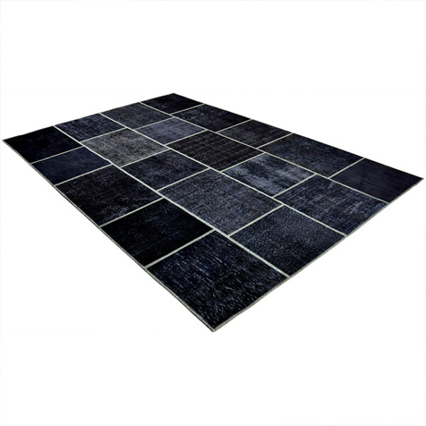 Diagonaal aanzicht van vloerkleed ANKARA patchwork, in de kleur zwart olijf gemaakt van wol.