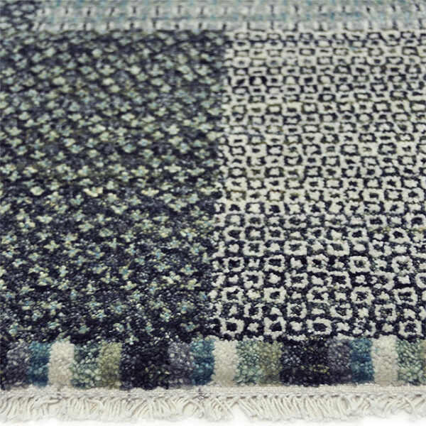 Zijkant detail aanzicht van vloerkleed BRETTI, in de kleur blauw zwart gemaakt van wol.