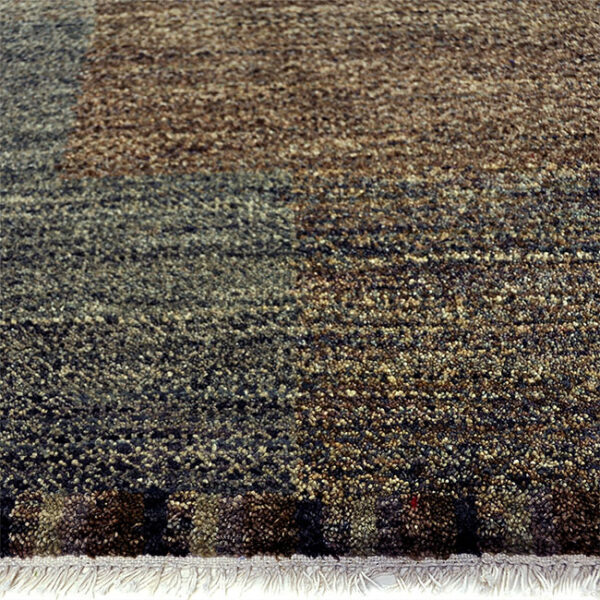 Zijkant detail aanzicht van vloerkleed BRETTI, in de kleur groen gemaakt van wol.