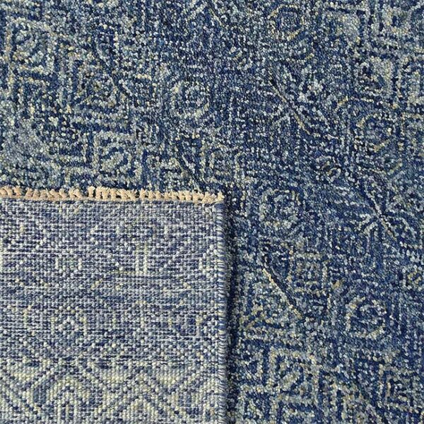 Achterkant hoek aanzicht van vloerkleed CANTELLO, in de kleur azure blauw gemaakt van wol.