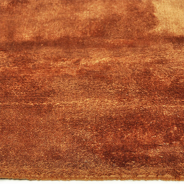 Zijkant detail aanzicht van vloerkleed FLAVIA, in de kleur koper gemaakt van viscose.