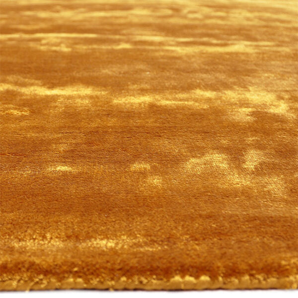 Zijkant detail aanzicht van vloerkleed FLAVIA, in de kleur oker gemaakt van viscose.