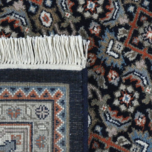 achterkant hoek aanzicht van vloerkleed HERATI, in de kleur blauw creme, gemaakt van wol.