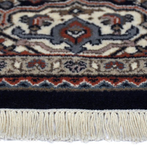 zijkant detail aanzicht van vloerkleed HERATI, in de kleur blauw creme, gemaakt van wol.