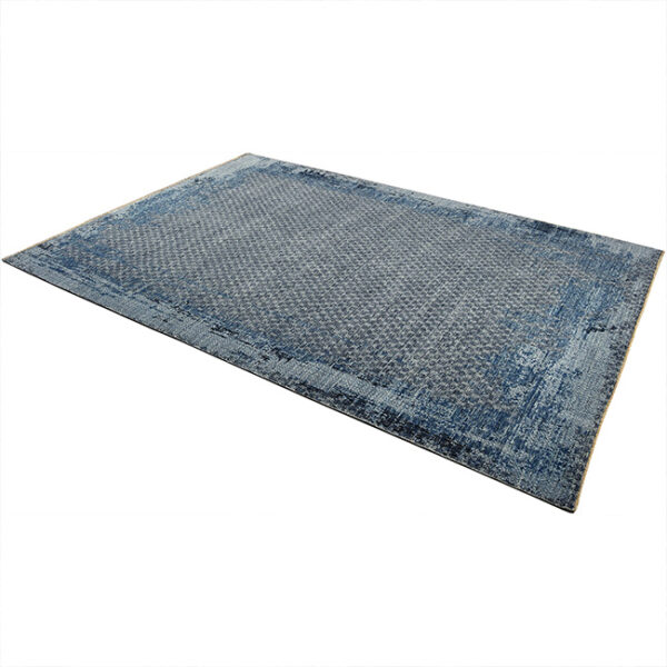 Diagonaal aanzicht van vloerkleed KARAKUM, in de kleur blauw gemaakt van wol.