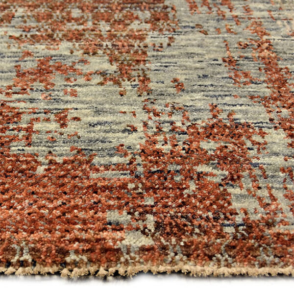 Zijkant detail aanzicht van vloerkleed KARAKUM, in de kleur roest gemaakt van wol.