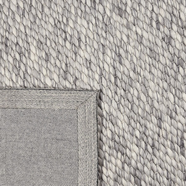 Achterkant hoek aanzicht van vloerkleed LANA, in de kleur wit grijs gemaakt van wol.