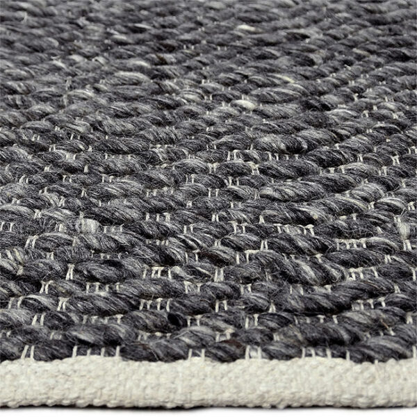 Zijkant detail aanzicht van vloerkleed LORENZO, in de kleur antraciet gemaakt van wol.