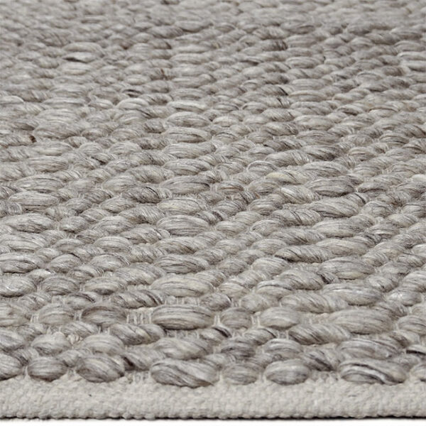 Zijkant detail aanzicht van vloerkleed LORENZO, in de kleur NT grijs gemaakt van wol.