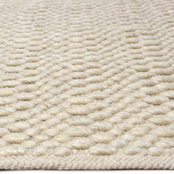 Zijkant detail aanzicht van vloerkleed LORENZO, in de kleur zilver gemaakt van wol.