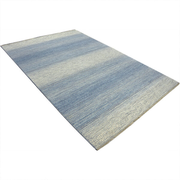 Diagonaal aanzicht van vloerkleed LUCERA, in de kleur ivoor blauw gemaakt van wol.