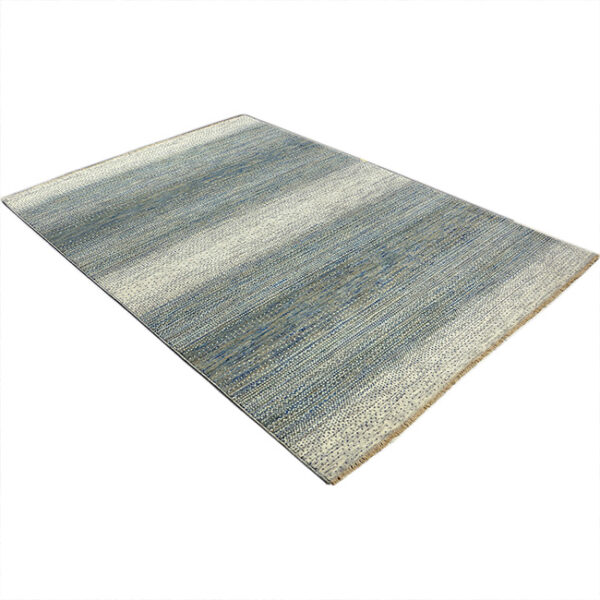 Diagonaal aanzicht van vloerkleed LUCERA, in de kleur ivoor groen gemaakt van wol.