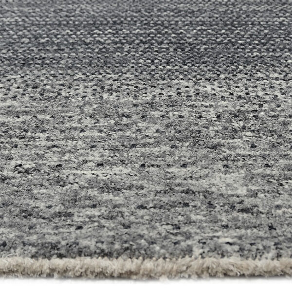 Zijkant detail aanzicht van vloerkleed LUCERA, in de kleur zwart grijs gemaakt van wol.