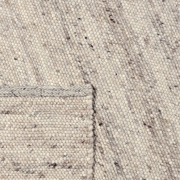 Achterkant hoek aanzicht van vloerkleed LUNI, in de kleur ivoor bruin gemaakt van wol.