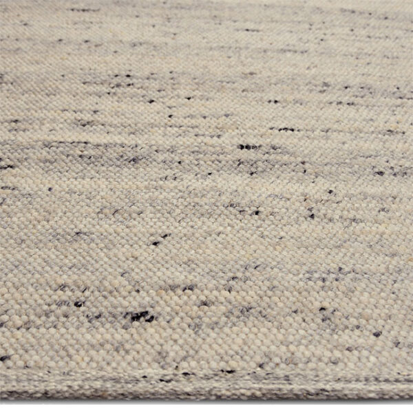 Zijkant detail aanzicht van vloerkleed LUNI, in de kleur ivoor gemaakt van wol.