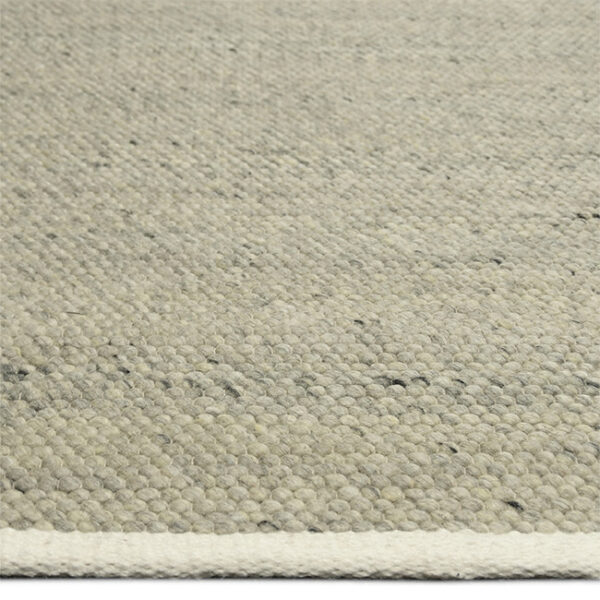 Zijkant detail aanzicht van vloerkleed MULA, in de kleur groen grijs gemaakt van een mix van wol.