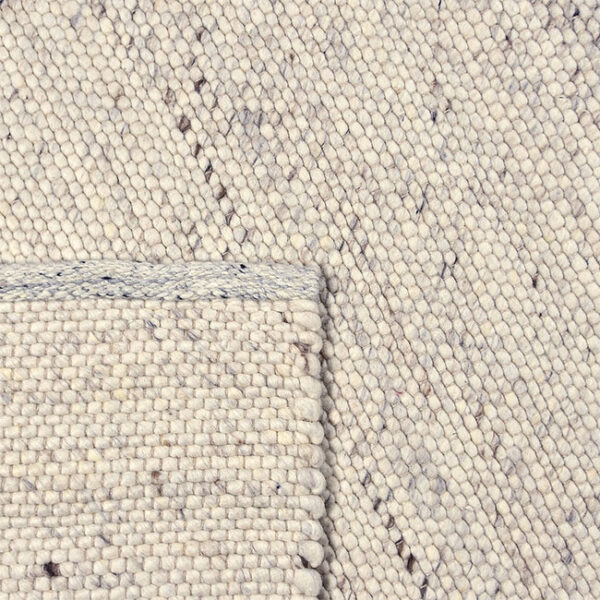 Achterkant hoek aanzicht van vloerkleed MULA, in de kleur Mellee gemaakt van een mix van wol.