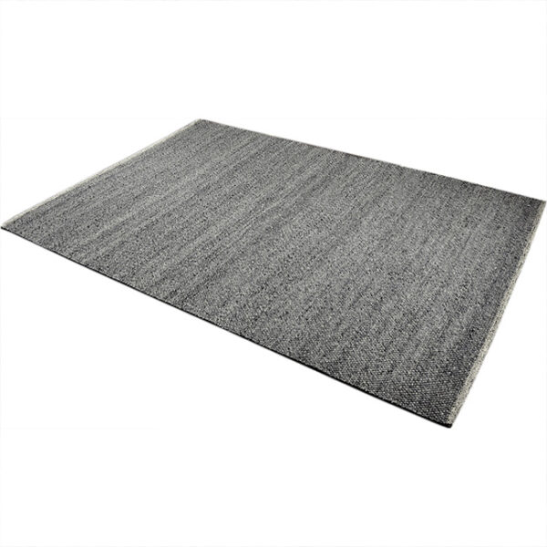 Diagonaal aanzicht van vloerkleed MULA, in de kleur midden grijs gemaakt van een mix van wol.