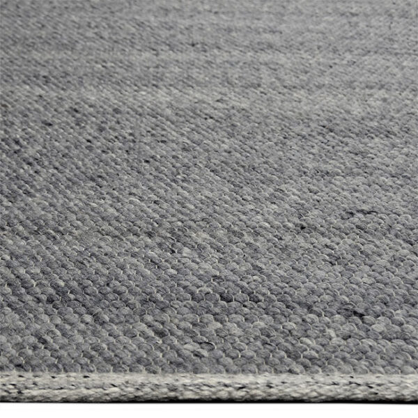 Zijkant detail aanzicht van vloerkleed MULA, in de kleur midden grijs gemaakt van een mix van wol.