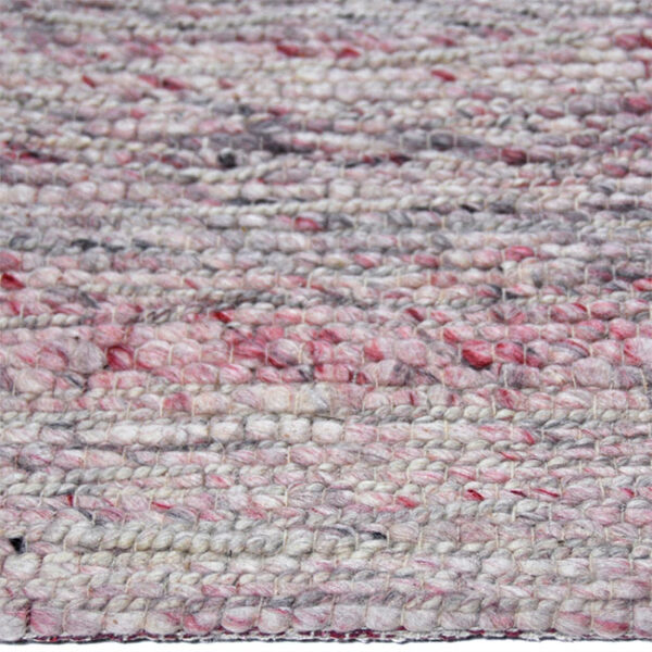 Zijkant detail aanzicht van vloerkleed NAVASSA, in de kleur beige naturel roze gemaakt van wol.