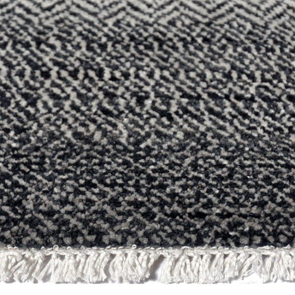 Zijkant detail aanzicht van vloerkleed PAMPAS, in de kleur zwart zilver gemaakt van wol.