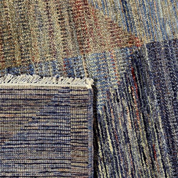 Achterkant hoek aanzicht van vloerkleed PATRI K, in de kleur blauw gemaakt van wol.