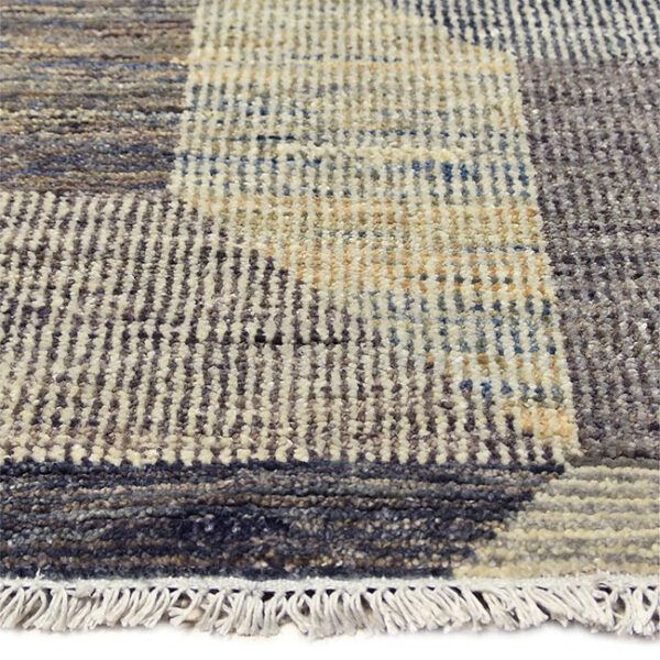 Zijkant detail aanzicht van vloerkleed PATRI K, in de kleur grijs gemaakt van wol.