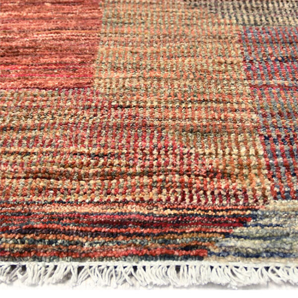 Zijkant detail aanzicht van vloerkleed PATRI K, in de kleur rood gemaakt van wol.