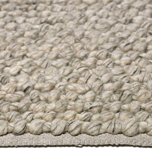 Zijkant detail aanzicht van vloerkleed RENO, in de kleur zilver gemaakt van wol.