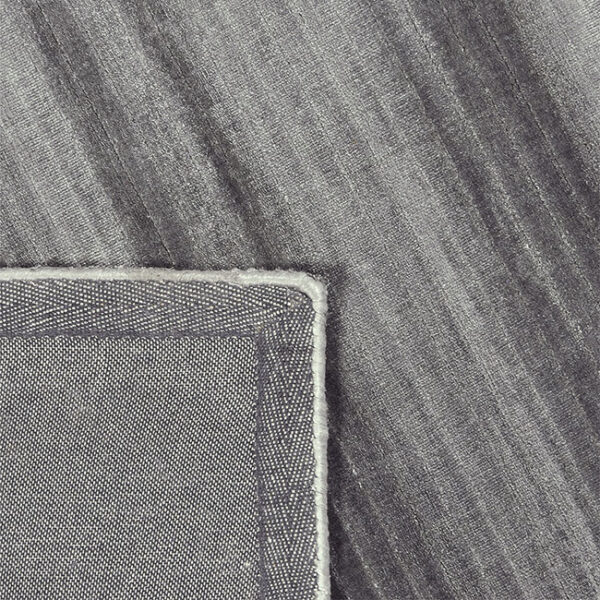 Achterkant hoek aanzicht van vloerkleed RIB, in de kleur grijs, gemaakt van viscose.