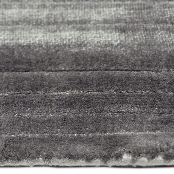 Zijkant detail aanzicht van vloerkleed RIB, in de kleur grijs, gemaakt van viscose.